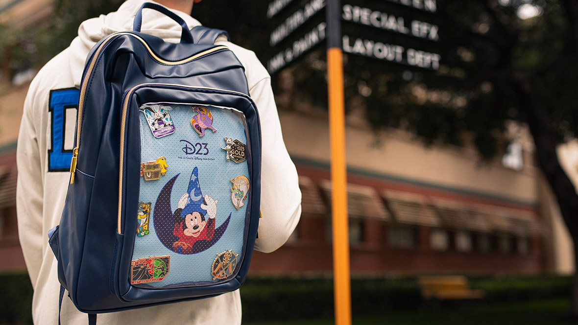 D23 Merch Man wearing a D23: The Ultimate Disney Fan Event exclusive backpack at the Walt Disney Studio Lot.